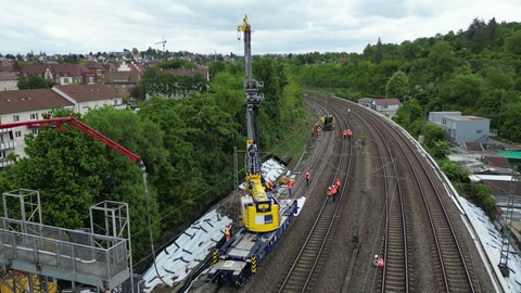 Bauarbeiten an der Bahnstrecke in Stuttgart-Bad Cannstatt für den Digitalen Knoten Stuttgart. (Archiv). Zu sehen sind Bauarbeiter mit Maschinen auf Bahn-Gleisen.