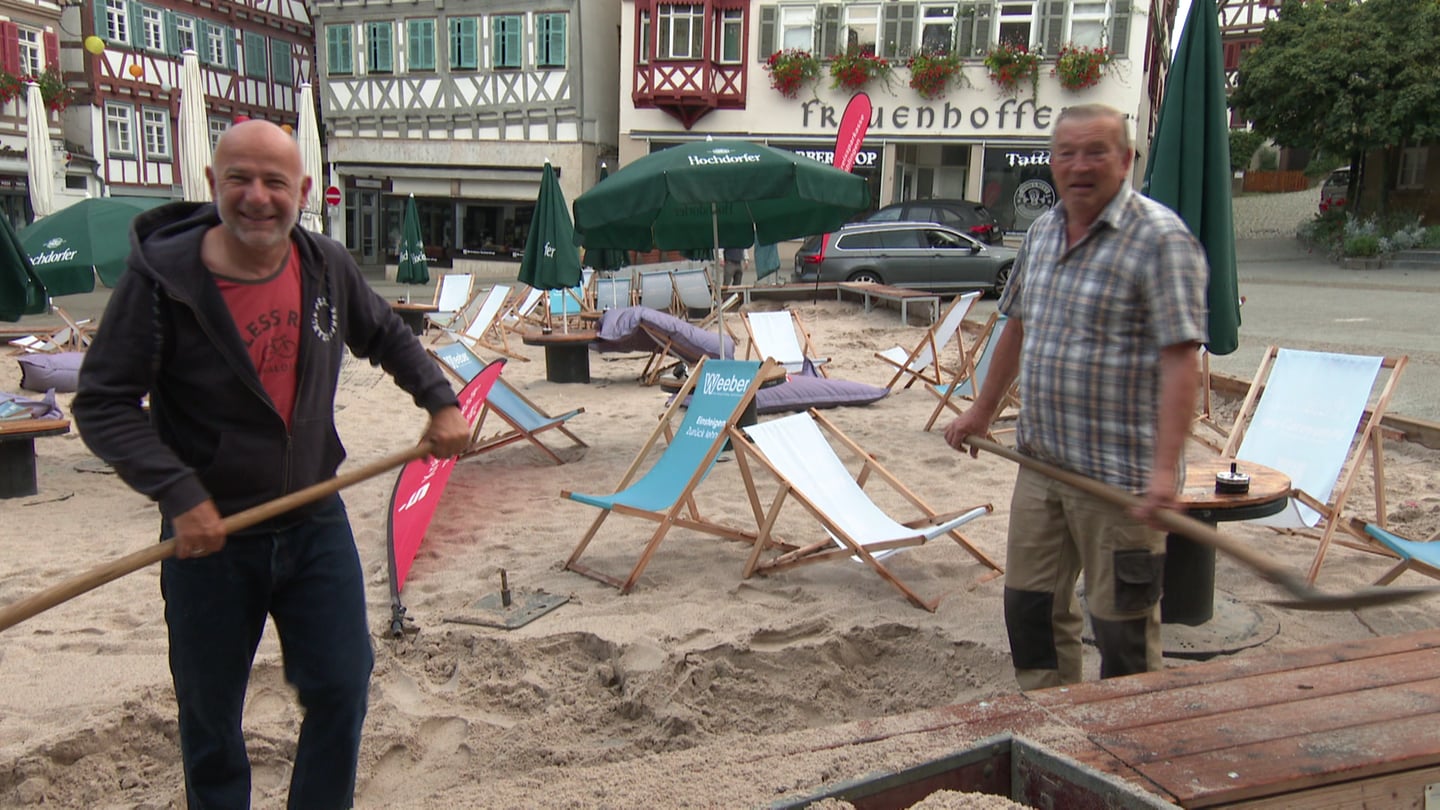 Zwei Männer schaufeln Sand in einen Hänger auf dem Marktplatz Herrenberg