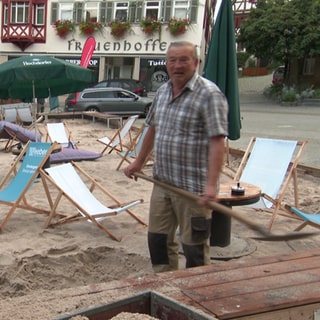 Zwei Männer schaufeln Sand in einen Hänger auf dem Marktplatz Herrenberg