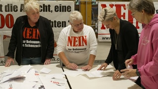 Die Bürgerinitiative bei der Abstimmung mit T-shirts und Plakaten gegen den Bau einer LEA.