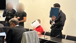 Drei Angeklagte beim Prozessauftakt im Landgericht Stuttgart: Sie sollen Molotowcocktails auf einen Friseursalon geworfen haben.