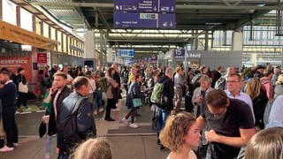 Viele Menschen stehen am Hauptbahnhof Stuttgart und warten auf ihre Züge, weil sie ausgefallen sind oder sich verspäten.