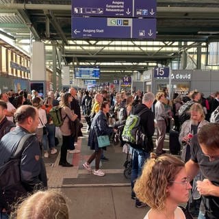 Viele Menschen stehen am Hauptbahnhof Stuttgart und warten auf ihre Züge, weil sie ausgefallen sind oder sich verspäten.