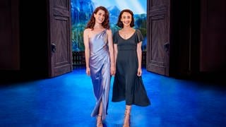 Ann Sophie und Abla Alaoui stehen vor der Kulisse des Disney-Musicals "Die Eiskönigin" in Stuttgart.