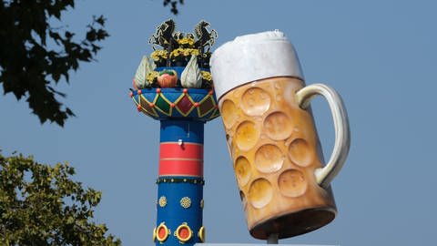 die Fruchtsäule hinter einem überdimensionierten Bierkrug auf dem Cannstatter Volksfest 2024