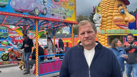 Der 1. Vorsitzende vom Schaustellerverband Stuttgart, Mark Roschmann, steht vor seinen beiden Attraktionen auf dem 177. Cannstatter Volksfest, im Oktober 2024, auf dem Wasen in Stuttgart-Bad Cannstatt.