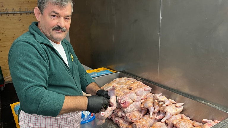 Los geht’s mit der Zubereitung: Erst kommen Salz, Pfeffer und Paprikapulver auf das Fleisch, danach befüllen die Mitarbeiter das Göckele mit Petersilie und spießen es zum Braten auf.