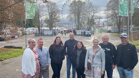 Cindy Gesell und ihre Gruppe aus Hagenau im Elsass stehen in Stuttgart vor dem Eingang des Cannstatter Wasen.