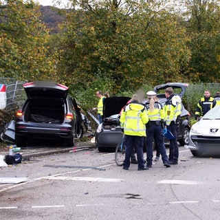 Beamtinnen und Beamte der Polizei stehen in Esslingen neben drei Fahrzeugen: Bei dem schweren Unfall sind eine Frau und ihre zwei Kinder gestorben.