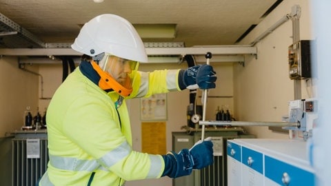 Techniker leitet in einer Umspannstation den Strom auf eine andere Leitung um. 