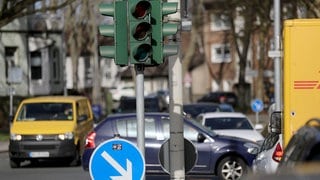 Autos stehen an einer ausgeschalteten Ampel.