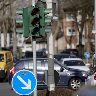 Autos stehen an einer ausgeschalteten Ampel.