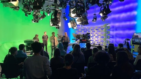 SWR-Reporter Hannes Köhle erklärt den Jugendlichen, wie sie gleich ihre eigene Fernsehsendung auf die Beine stellen.