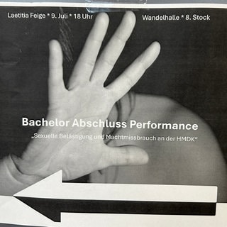 Ein graues Plakat mit der Aufschrift "Bachelor-Abschluss-Performance - Sexuelle Belästigung und Machtmissbrauch an der HMDK".