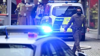 Ein Polizist mit Sturmhaube geht durch die Esslinger Innenstadt, wo am Donnerstag ein Mann einen anderen und sich selbst getötet haben soll.