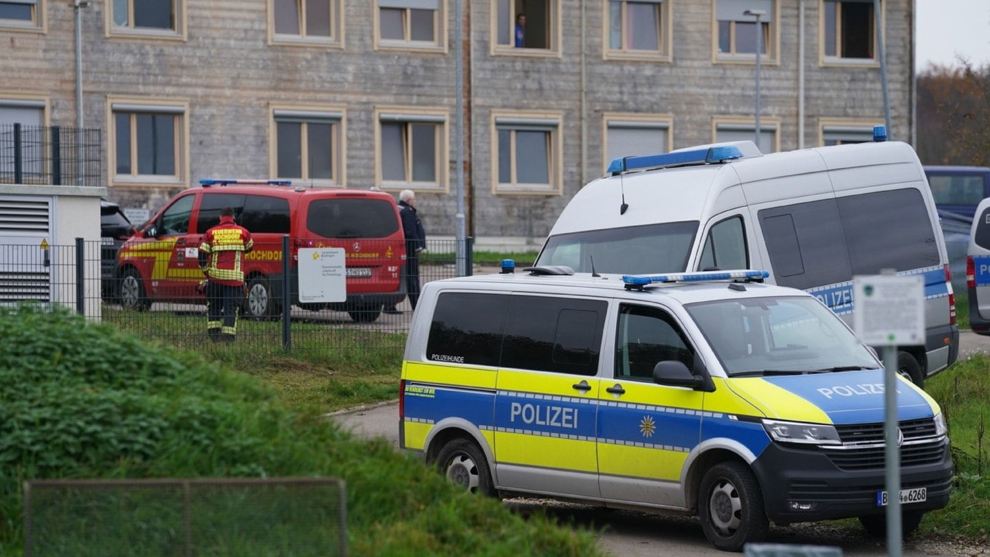 Zwei Streifenwagen der Polizei stehen vor einer Asylunterkunft in Hochdorf (Kreis Esslingen).