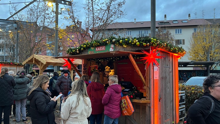 Lange Menschenschlange vor Kasse auf dem Weihnachtsmarkt von Aldi Süd in Stuttgart-Bad Cannstatt