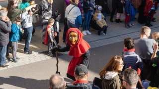 Eine einsame Fasnet-Hexe zwischen den Zuschauern bei einem Fasnetumzug in Neckarweihingen. (Archivbild)