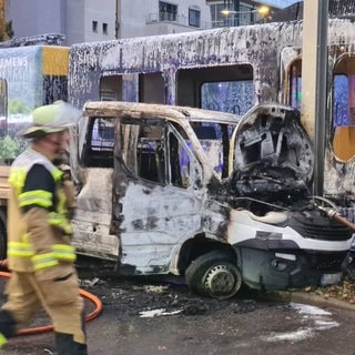 Ein ausgebrannter Kleinlaster steht neben einer S-Bahn. In Stuttgart-Vaihingen ist ein Kleintransporter mit einer Stadtbahn kollidiert. Der Transporter hat Feuer gefangen.