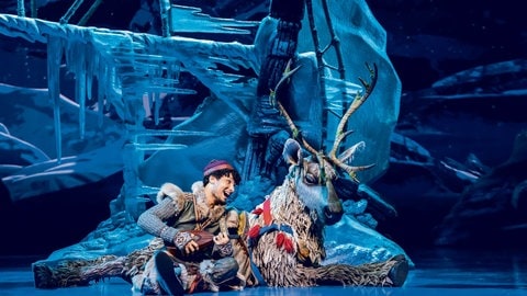 Kristoff und liegt mit seinem Rentier Sven zusammen auf der Bühne des Musicals "Die Eiskönigin" in Stuttgart.