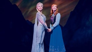 Anna und Elsa stehen im Musical "Die Eiskönigin" in Stuttgart nebeneinander auf der Bühne.