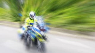 Ein Polizist fährt auf einem Motorrad in Stuttgart auf der Straße. (Symbolbild)