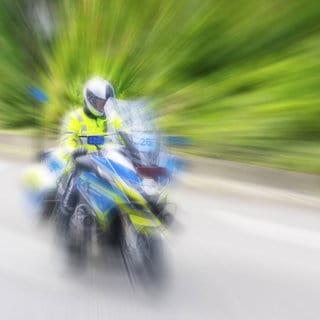 Ein Polizist fährt auf einem Motorrad in Stuttgart auf der Straße. (Symbolbild)