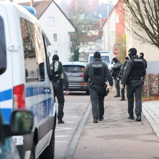 Polizisten des Sondereinsatzkommandos (SEK) laufen durch Reichenbach ann der Fils, nachdem ein Haus gestürmt wurde. 