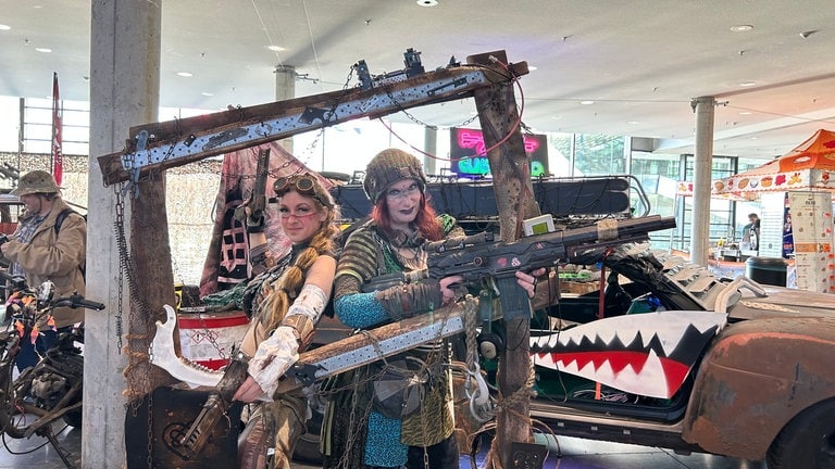 Es erinnert an "Mad Max", wie zwei verkleidete Besucherinnen der Comic Con Stuttgart aussehen und in die Kamera schauen.