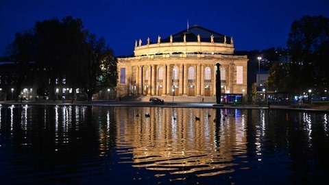 Das Operngebäude in Stuttgart, der Littmann-Bau, spiegelt sich in der Dämmerung im Eckensee.