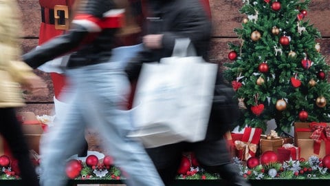 Passanten gehen an einem weihnachtlich geschmückten Verkaufsstand auf der Königstraße in Stuttgart vorbei. (Archivbild)