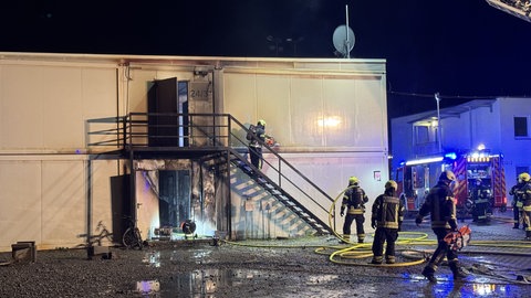 Einsatzkräfte der Feuerwehr löschen einen Brand in einer Asylunterkunft in Winnenden (Rems-Murr-Kreis).