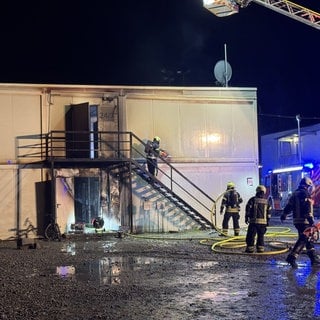 Einsatzkräfte der Feuerwehr löschen einen Brand in einer Asylunterkunft in Winnenden (Rems-Murr-Kreis).