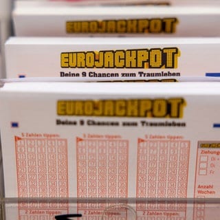 Eurojackpot Spielscheine stehen in einem Regal in einer Lotto-Annahmestelle. 