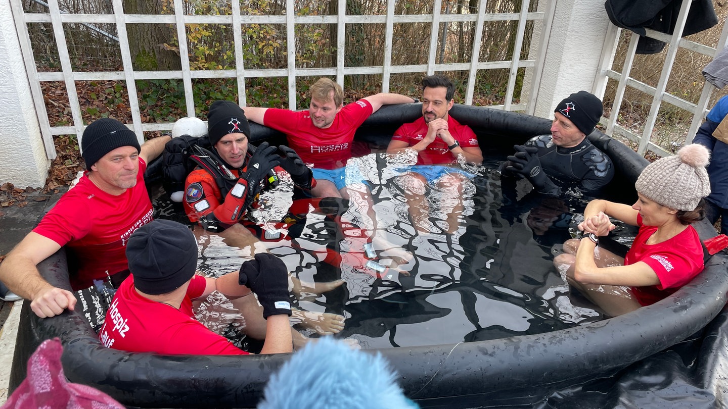 Mehrere Menschen sitzen bekleidet in einer großen Tonne mit Eiswasser, darunter Ex-VfB-Profi Timo Hildebrand.