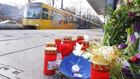 Blumen und Kerzen stehen an der Haltestelle Max-Eyth-See. Ein 13-Jähriger soll hier am Vortag einen 12-Jährigen nach einem Streit gegen eine einfahrende Stadtbahn gestoßen haben.