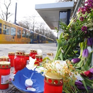 Blumen und Kerzen stehen an der Haltestelle Max-Eyth-See. Ein 13-Jähriger soll hier am Vortag einen 12-Jährigen nach einem Streit gegen eine einfahrende Stadtbahn gestoßen haben.