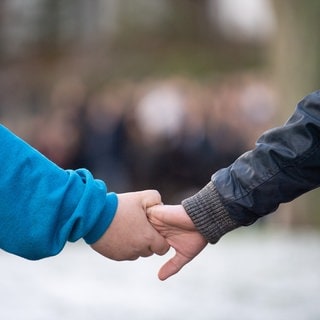 Schüler halten sich während der Gedenkfeier des Amoklaufs von Winnenden in einer Menschenkette an der Hand. (Archivbild)