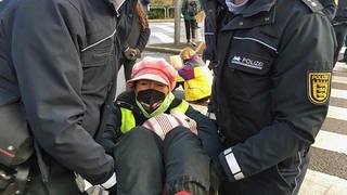 Polizei trägt Aktivisten von Straße
