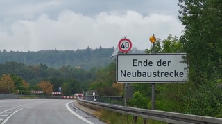 Schild neben Straße mit Aufschrift "Ende Neubaustrecke"  