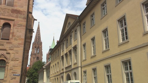 In the foreground is a tall, bright building - in the background you can see the Freiburg Minster tower.  (photo: SWR)