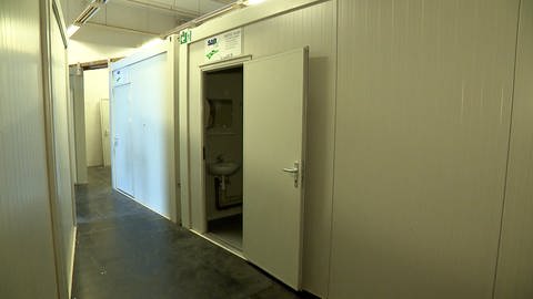 ein Container in einer Halle mit geöffneter Tür