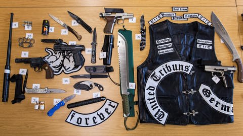 Zahlreiche beschlagnahmte Waffen und eine Lederjacke der rockerähnlichen Gruppierung "United Tribuns" (Archivfoto).