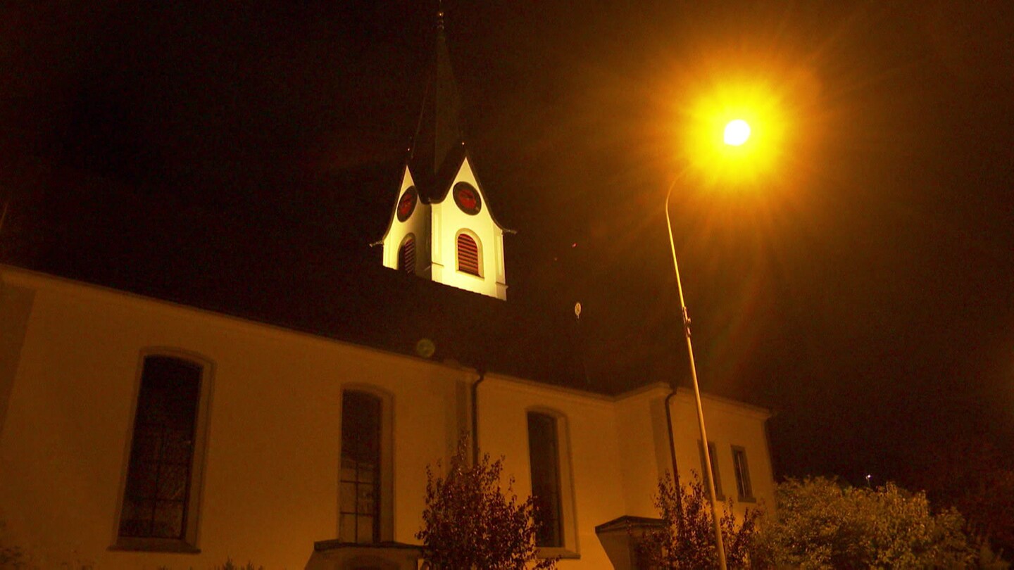 Eine Kirche mit einer Straßenlaterne, die leuchtet