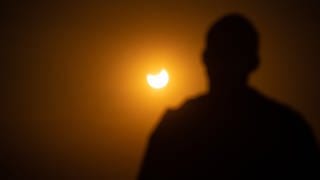 Menschen in Freiburg beobachten fasziniert die partielle Sonnenfinsternis