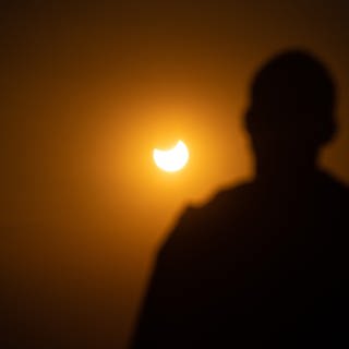 Menschen in Freiburg beobachten fasziniert die partielle Sonnenfinsternis