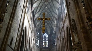 Goldenes Kreuz hängt über dem Altarraum im Freiburger Münster.