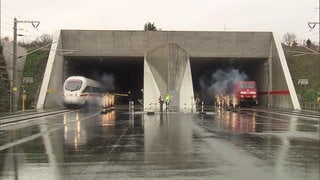 Ein ICE und ein Güterzug durchfahren mit Feuerwerk den Katzenbergtunnel bei der Eröffnung 2012