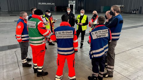 Lagebesprechung der Rettungsdienste zum provisorischen Behandlungsplatz in der Messe Freiburg