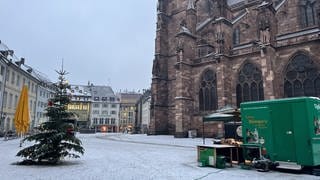 Markt vor dem Freiburger Münster ist leerer als üblich. Nur zwei Stände sind aufgebaut. Schnee liegt auf dem Boden.
